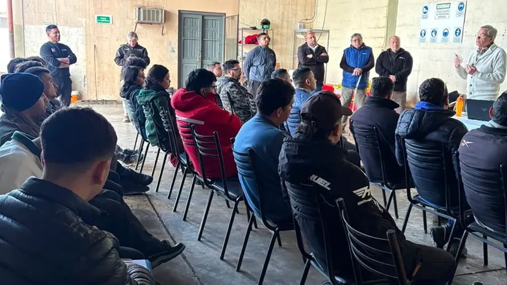 Alumnos tomando clases en un galpón comercial. 