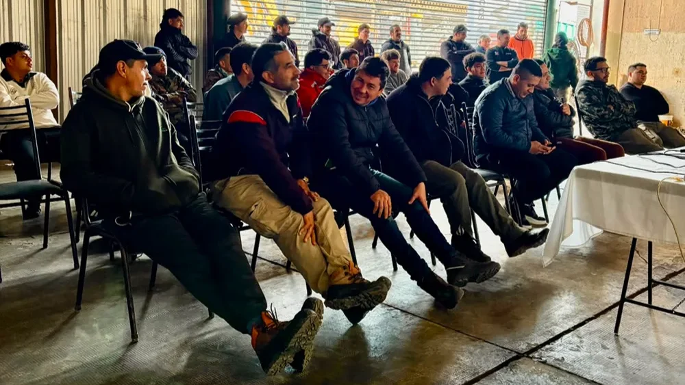 galpon con operarios sentados escuchado una charla