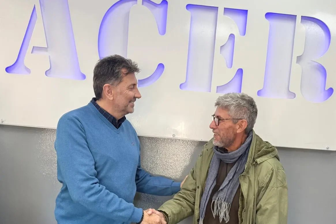 Patricio Paez Y Claudio García ratificando el acuerdo de colaboración estrechándose las manos 