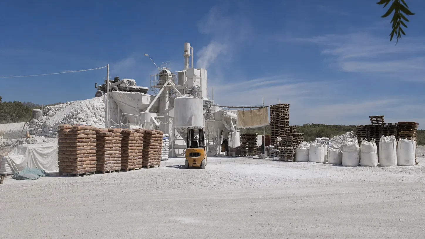 planta calera de Los Berros con bolsas, pallets, maquinaria y acopio de cal.