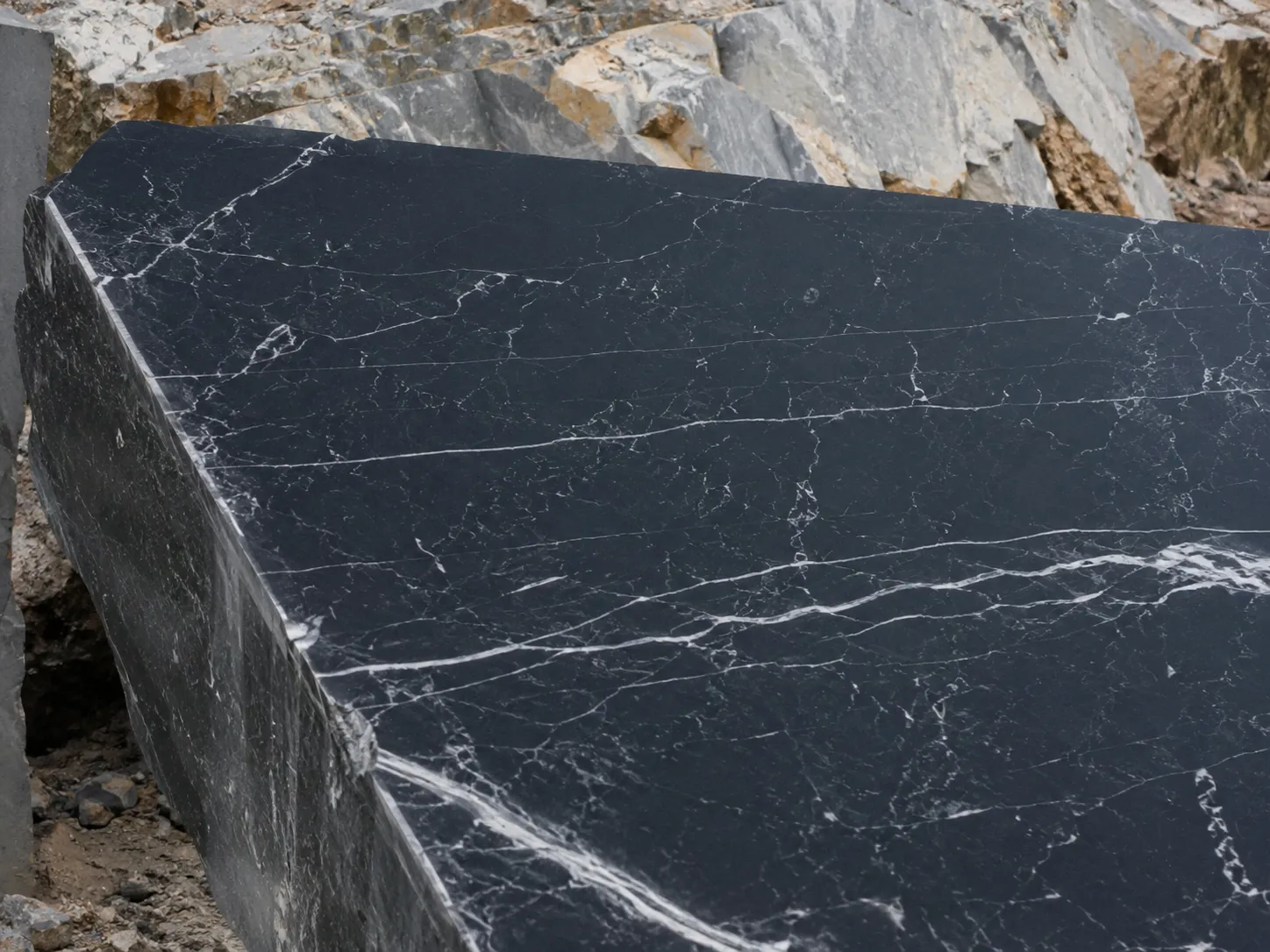 Bloque de mármol negro con vetas blancas en cantera de piedra ornamental.