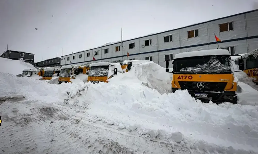 equipos mineros frente a un campamento minero, todo cubierto por nieve