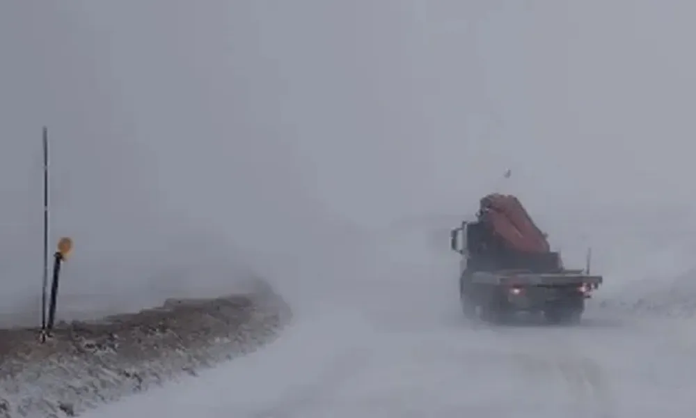 camion andando por un camino de nieve y visibilidad reducida