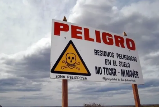 Cartel de peligro por residuos peligrosos e impacto ambiental de los pasivos mineros Bahía San Antonio.