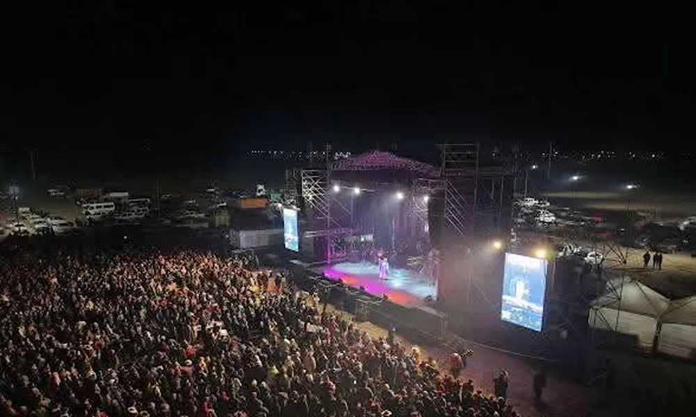 Escenario de gran formato con iluminación, pantallas y público durante un espectáculo musical nocturno realizado en el departamento Sarmiento, San Juan.