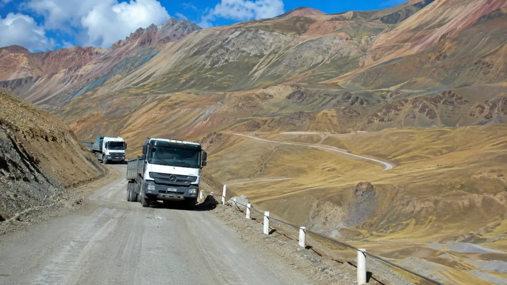 Camino de cordillera con camiones transitando.