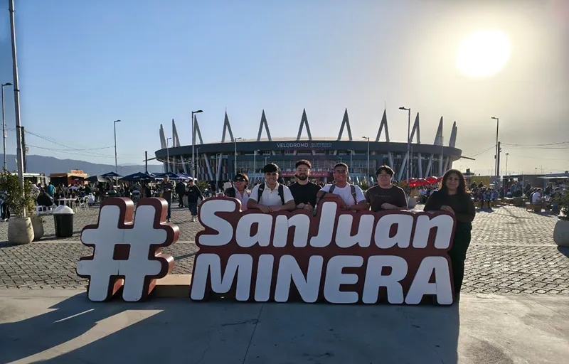 Integrantes del equipo posan detrás de una estructura identificatoria de San Juan Minera en el exterior del Velódromo Vicente