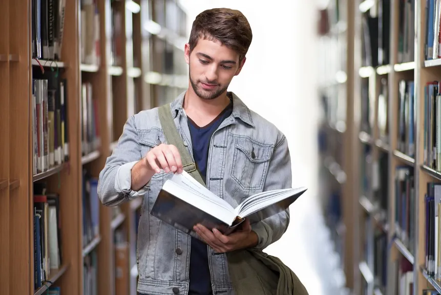 Estudiante leyendo un libro  en la biblioteca.