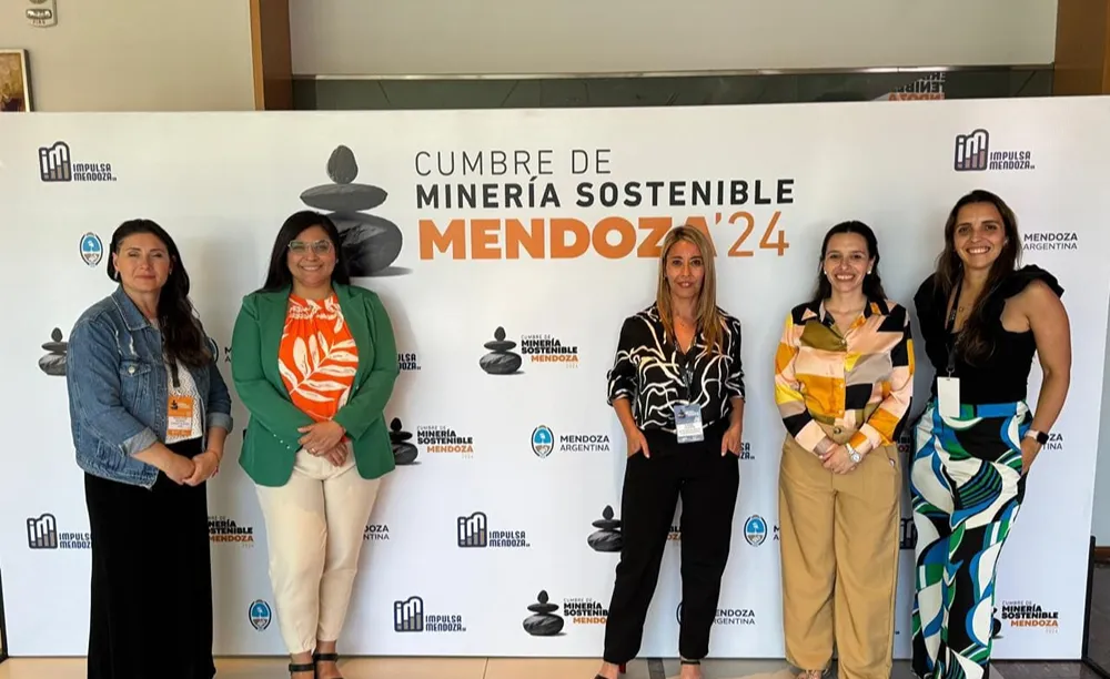Susana Figueroa junto a otras referentes durante la Cumbre de Minería Sostenible Mendoza 2024, frente al panel institucional del encuentro.