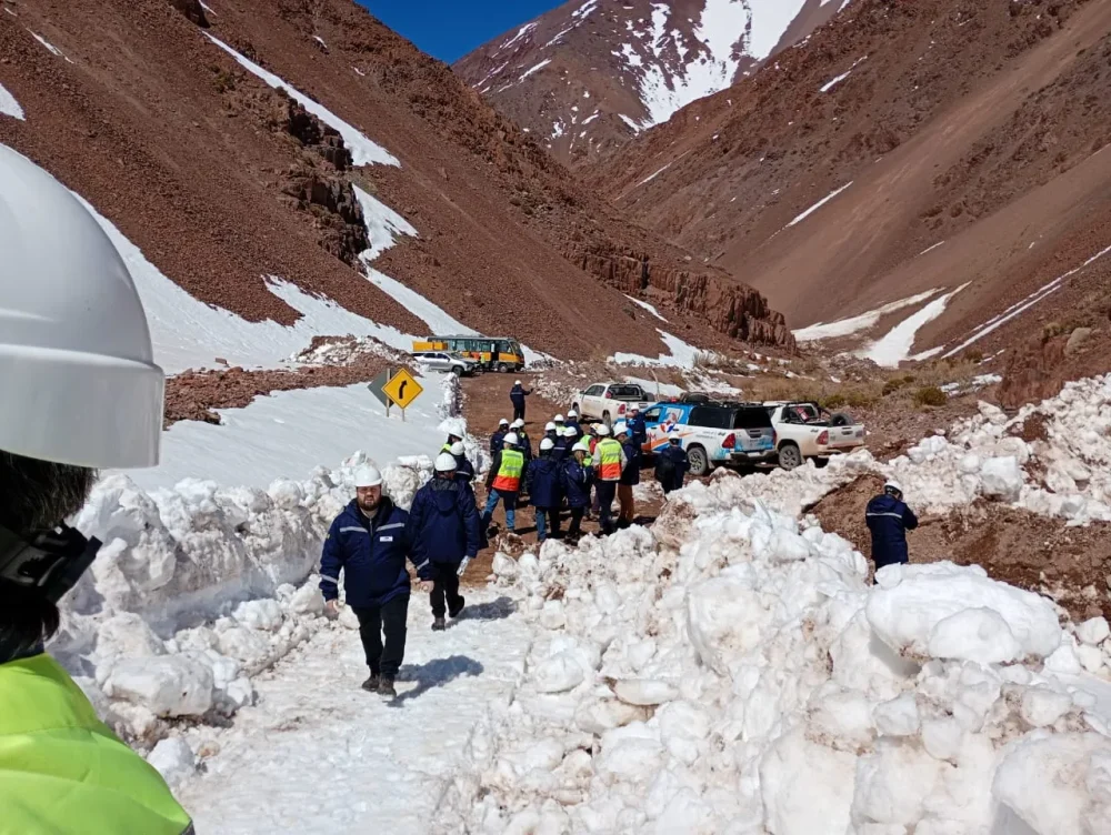 grupo de personas subiendo un camino montañoso con nieve