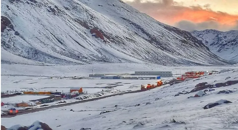 Contenido Original de ACERO Y ROCA - Prohibida su reproducción Vista aérea del Campamento Los Azules, mostrando estructuras modulares, vehículos 4x4 y actividad operativa en un valle andino remoto a gran altitud.