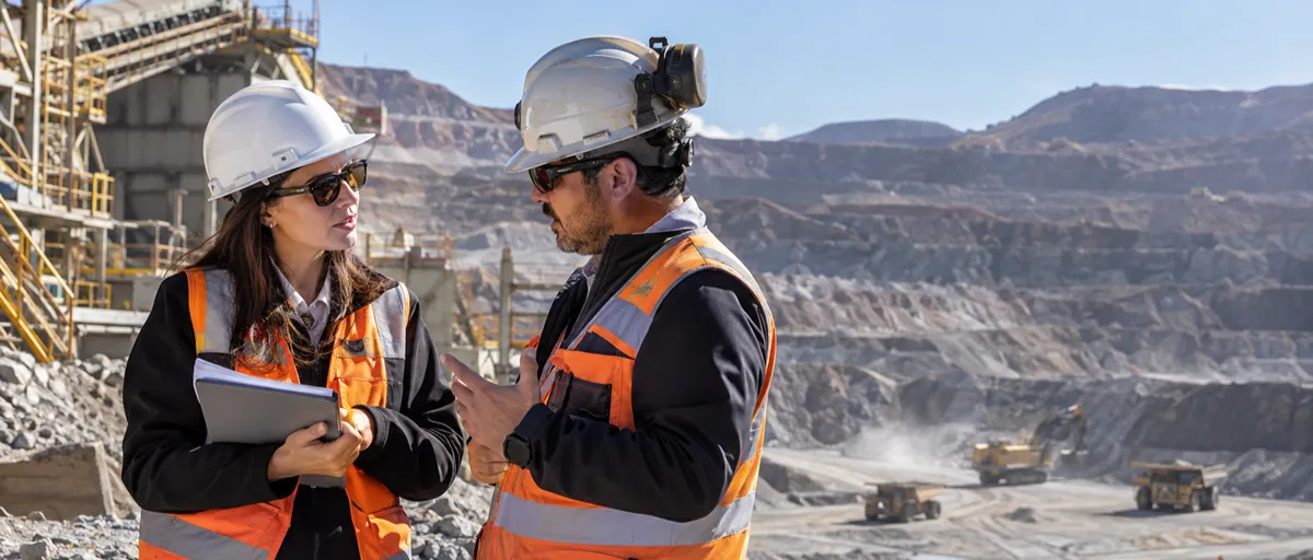 Trabajadores en yacimiento minero analizando viabilidad ante el riesgo país inversiones mineras.