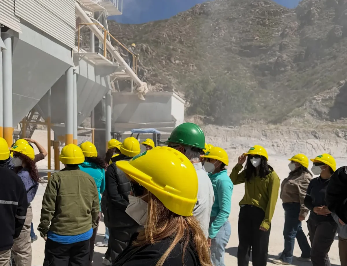 Estudiantes y participantes con cascos de seguridad recorren instalaciones de una planta calera ubicada en el departamento Sarmiento.