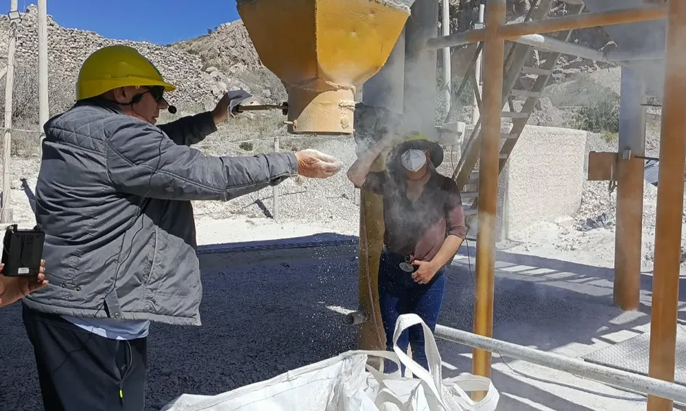 Demostración de material mineral fino durante el proceso de embolsado en Más Minerales, planta ubicada en Sarmiento.