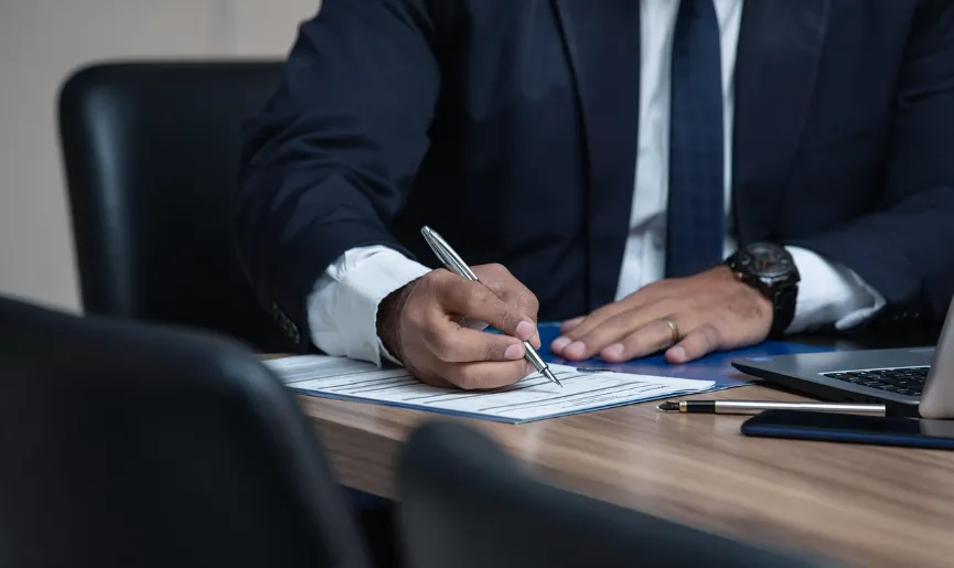 Ejecutivo firmando documentos y contratos de financiamiento comercial.
